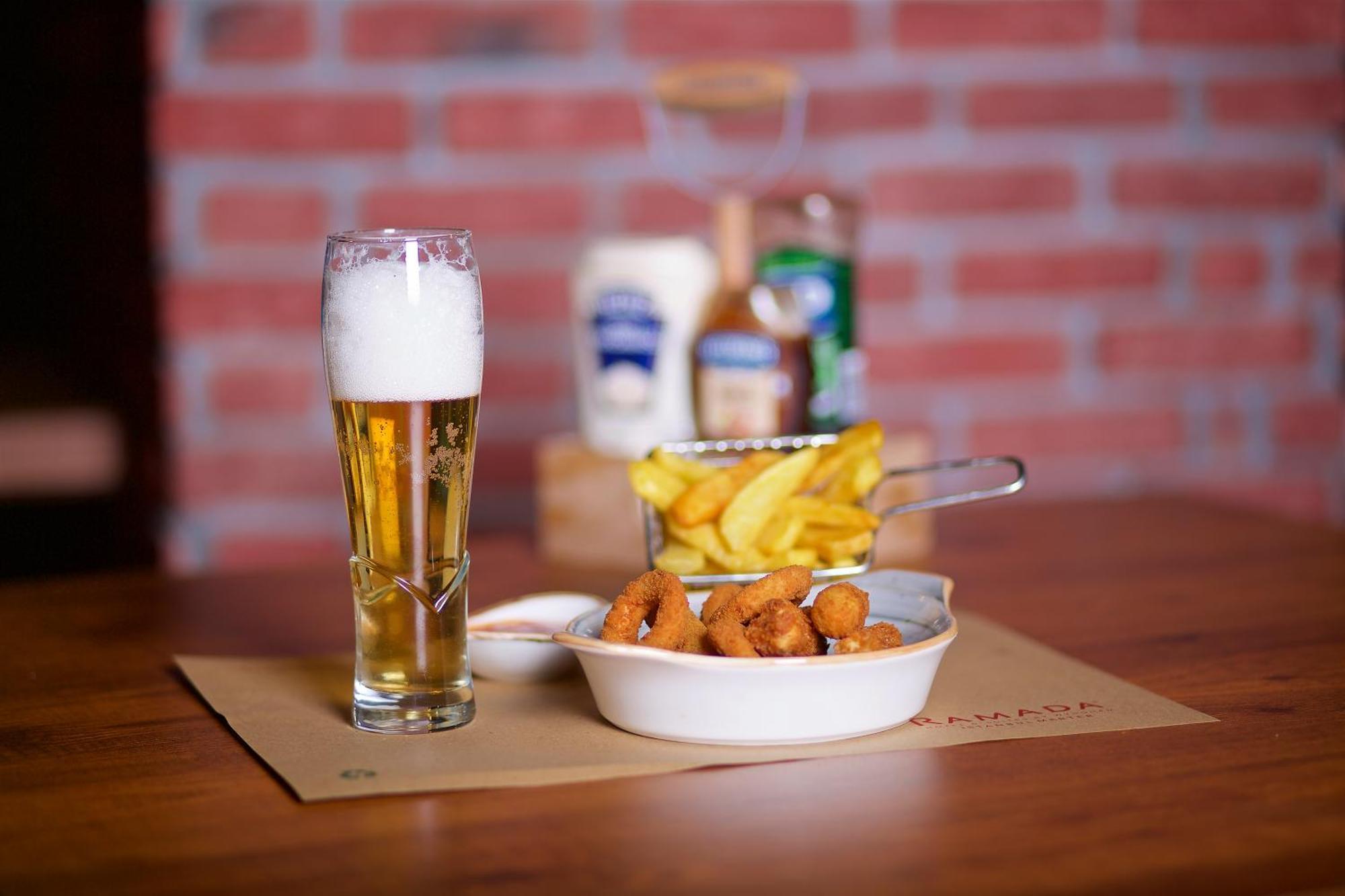 Ramada By Wyndham Istanbul Merter Esterno foto A glass of beer with patatas fritas and croquetas